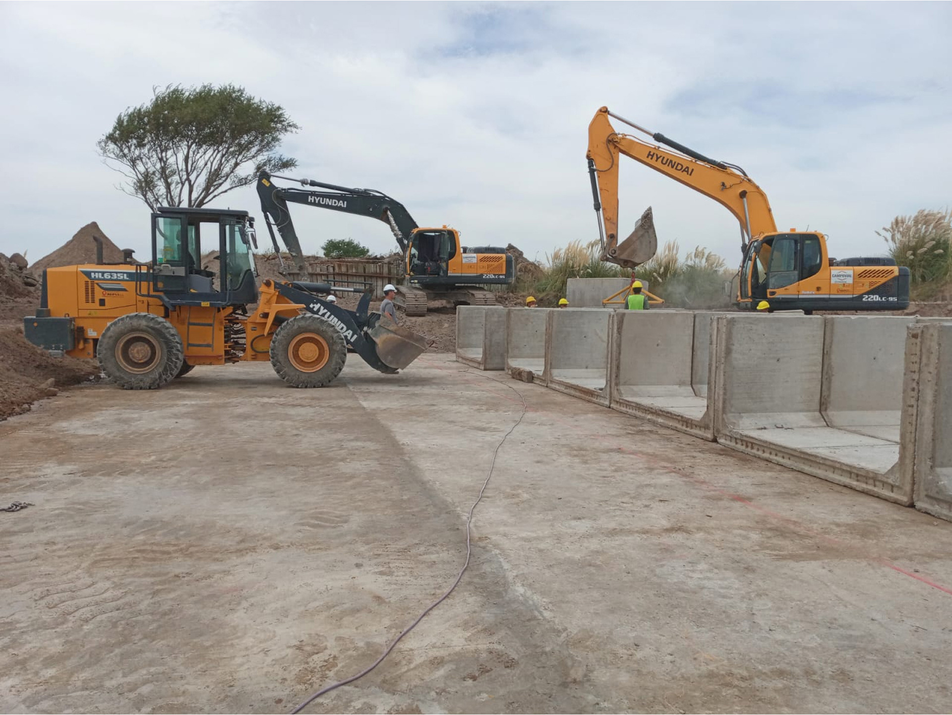 Obras de renovación del puente ferroviario en América con maquinaria pesada y estructuras de hormigón en construcción.