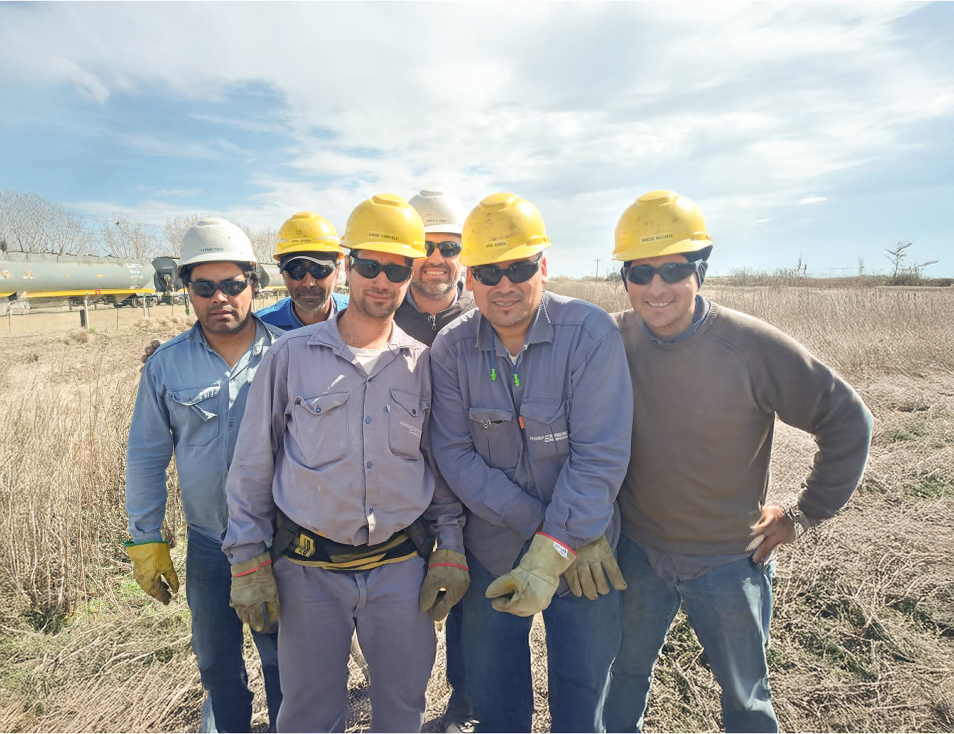 Equipo de trabajadores ferroviarios con cascos y uniformes en obra de renovación del desvío ferroviario Napostá.